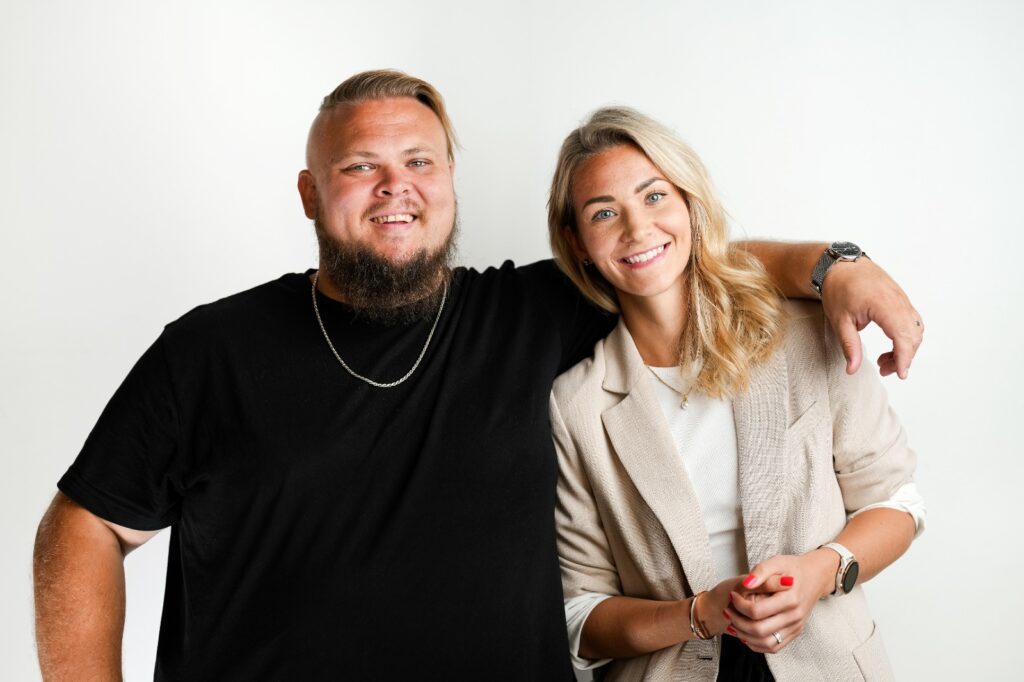 Growthland founders Maria Hugg and Mikael Hugg standing in front of white background canvas in a photo studio